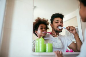 Man Brushing Child's Teeth