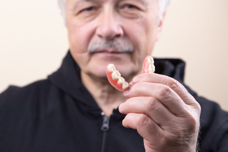 Man Holding Dentures